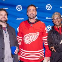 Group of three young gentlemen standing in front of GVSU backdrop